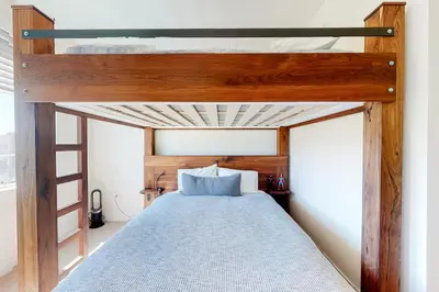a bedroom with a bunk bed with a blue bedspread at Modern Mountain Getaway in Winter Park