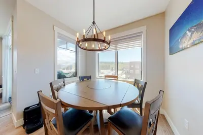 a dining room with a table and chairs and a chandelier at Modern Mountain Getaway in Winter Park