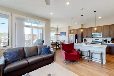 a living room with a couch and a kitchen at Modern Mountain Getaway in Winter Park