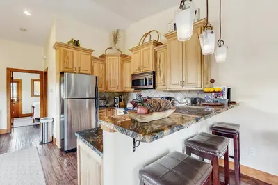 a kitchen with wooden cabinets and a stainless steel refrigerator at Modern Grand Lake Luxury in Grand Lake