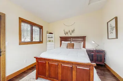 a bedroom with a wooden bed and a wooden dresser at Modern Grand Lake Luxury in Grand Lake