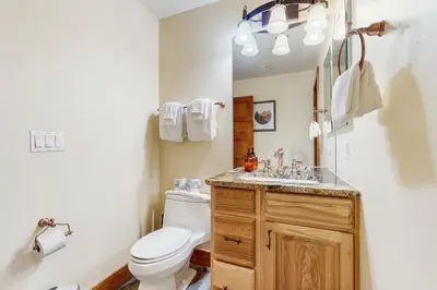 a bathroom with a toilet and a sink and a mirror at Modern Grand Lake Luxury in Grand Lake