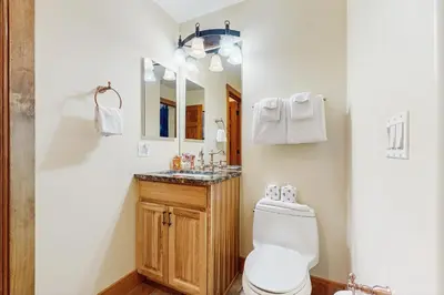 a bathroom with a toilet and a sink and a mirror at Modern Grand Lake Luxury in Grand Lake