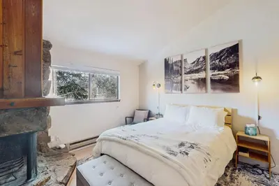 a bedroom with a bed and a fireplace at Rustic Relaxation in Winter Park in Winter Park