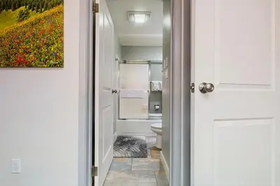a bathroom with a toilet and a painting on the wall at Rustic Relaxation in Winter Park in Winter Park