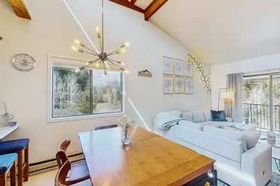 a living room with a table and a couch at Rustic Relaxation in Winter Park in Winter Park