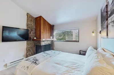 a bedroom with a bed and a flat screen tv at Rustic Relaxation in Winter Park in Winter Park