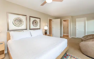 a bedroom with a large white bed and a chair at Cliffview Luxury Vacation Rental at Windcliff home in Estes Park