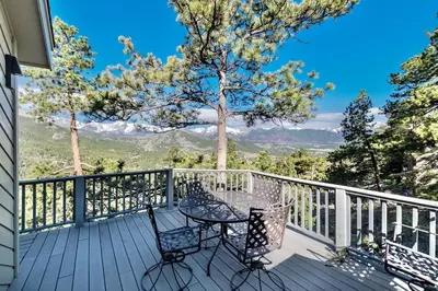 a patio with a table and chairs on a deck at Cliffview Luxury Vacation Rental at Windcliff home in Estes Park