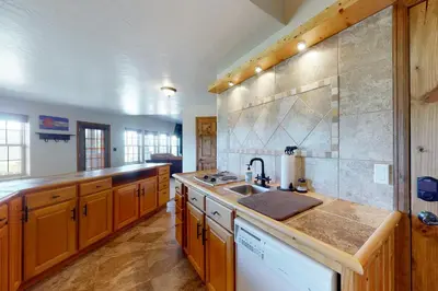 a large kitchen with wooden cabinets and a sink at Summer's End in Granby