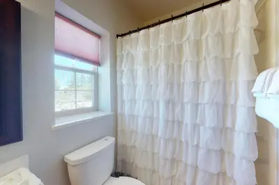 a white bathroom with a toilet and a window at Summer's End in Granby