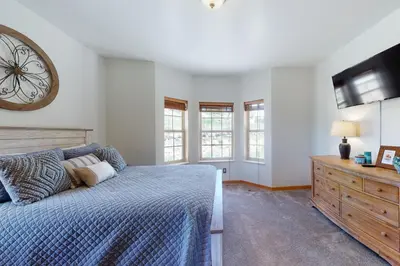 a bedroom with a bed and a clock on the wall at Summer's End in Granby