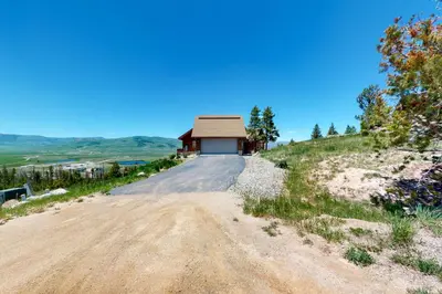 a dirt road leading to a building on a hill at Summer's End in Granby