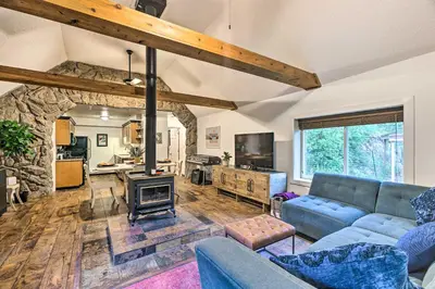 a living room with a couch and a fireplace at Creekside Morrison Cabin about 9 Mi to Red Rocks Park! in Morrison