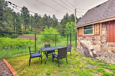a table and chairs in the backyard of a house at Creekside Morrison Cabin about 9 Mi to Red Rocks Park! in Morrison