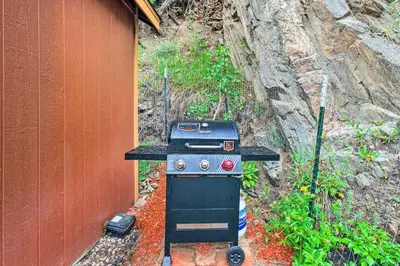 a stove sitting next to a building next to a wall at Creekside Morrison Cabin about 9 Mi to Red Rocks Park! in Morrison