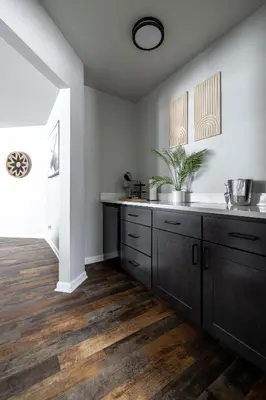a kitchen with black cabinets and wood floors at Winter Park Chateau in Winter Park