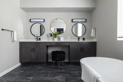 a bathroom with a sink and two mirrors at Winter Park Chateau in Winter Park
