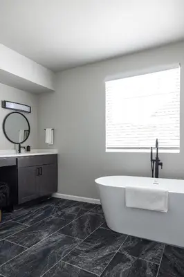 a white bathroom with a tub and a mirror at Winter Park Chateau in Winter Park