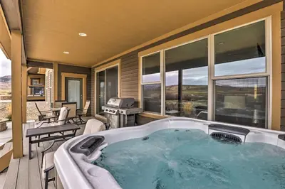 a jacuzzi tub on a porch with a patio at 3 Mi to Granby Ranch Home with Hot Tub and Mtn Views! in Granby