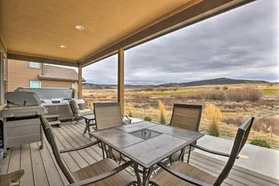 a deck with a table and chairs and a grill at 3 Mi to Granby Ranch Home with Hot Tub and Mtn Views! in Granby