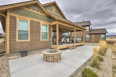 a house with a fire pit in front of it at 3 Mi to Granby Ranch Home with Hot Tub and Mtn Views! in Granby