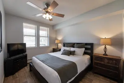 a bedroom with a bed with a ceiling fan and a television at Premium Unit 4568 - One Bedroom withKitchenette - Fraser Crossing Founders Pointe condo in Winter Park