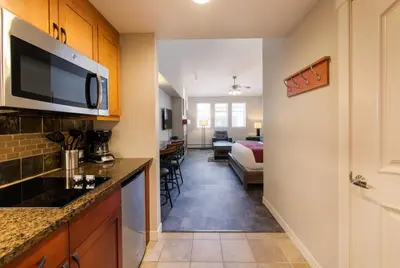 a kitchen with a counter and a living room at Premium Unit 4667 - Studio - Fraser Crossing Founders Pointe condo in Winter Park