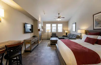 a bedroom with a large bed and a living room at Premium Unit 4667 - Studio - Fraser Crossing Founders Pointe condo in Winter Park