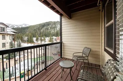 a balcony with two chairs and a table and a window at Premium Unit 4547 - One Bedroom withKitchenette - Fraser Crossing Founders Pointe condo in Winter Park