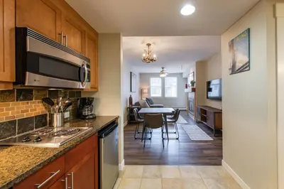 a kitchen and living room with a table in the background at Premium Unit 4547 - One Bedroom withKitchenette - Fraser Crossing Founders Pointe condo in Winter Park