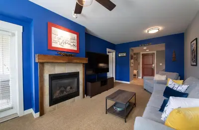 a living room with blue walls and a fireplace at Premium Unit 4466 - One Bedroom withKitchenette - Fraser Crossing Founders Pointe condo in Winter Park