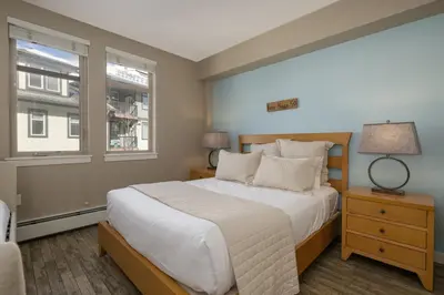 a bedroom with a large bed and two windows at Value Unit 4440 - Two Bedroom - Fraser Crossing Founders Pointe condo in Winter Park