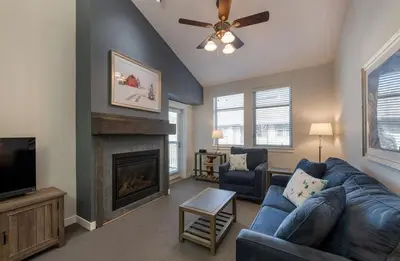 a living room with a blue couch and a fireplace at Winter Park FF Premium-Rated 3619 in Winter Park
