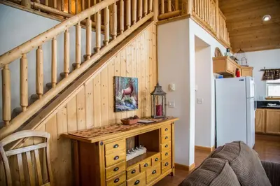 a kitchen with a staircase and a refrigerator at Old Man Mountain, Spacious lodge with loft Great for families, Dogs allowed in Estes Park