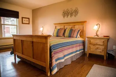 a bedroom with a wooden bed with two lamps on it at Old Man Mountain, Spacious lodge with loft Great for families, Dogs allowed in Estes Park