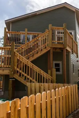 a house with a wooden deck and a fence at Spacious 2nd story loft with awesome views in Estes Park