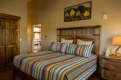 a bedroom with a bed with a striped comforter at Spacious 2nd story loft with awesome views in Estes Park