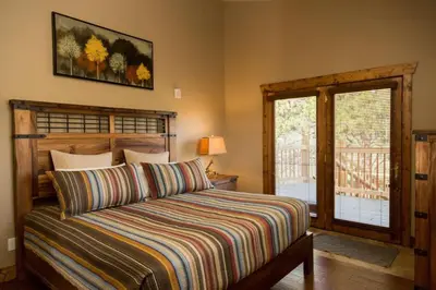 a bedroom with a bed with a striped comforter at Spacious 2nd story loft with awesome views in Estes Park