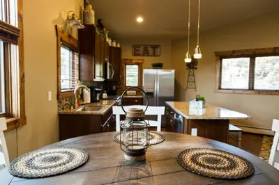 a kitchen with a wooden table with a lantern on it at Spacious 2nd story loft with awesome views in Estes Park