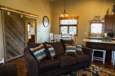 a living room with a brown couch and a kitchen at Spacious 2nd story loft with awesome views in Estes Park