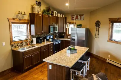 a kitchen with wooden cabinets and a stainless steel refrigerator at Spacious 2nd story loft with awesome views in Estes Park