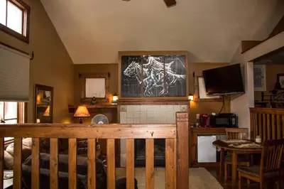 a living room with a bed and a television at Mummy Mtn Suite 1 Bedroom suite with fireplace and jacuzzi tub in Estes Park