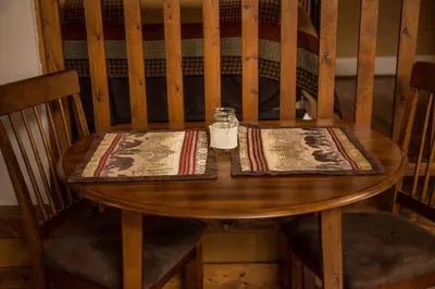 a wooden table with a napkin and a bottle on it at Mummy Mtn Suite 1 Bedroom suite with fireplace and jacuzzi tub in Estes Park