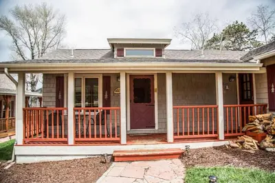 a small house with a porch with a deck at Mummy Mtn Suite 1 Bedroom suite with fireplace and jacuzzi tub in Estes Park