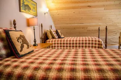 a bedroom with a bed and a couch in a room at Twin Owls Lodge, Great for families Master bedroom, Loft, full kitchen, Dogs OK in Estes Park