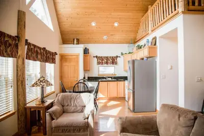 a kitchen with a refrigerator and a table and chairs at Twin Owls Lodge, Great for families Master bedroom, Loft, full kitchen, Dogs OK in Estes Park