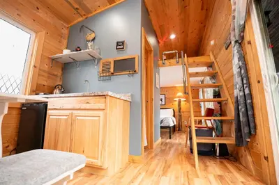 a small kitchen with a staircase in a tiny house at WeeCasa Tiny Home Resort in Lyons