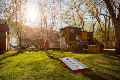 a group of people playing in a yard with a house at WeeCasa Tiny Home Resort in Lyons