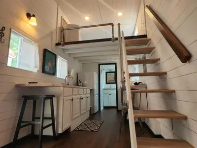 a kitchen with a staircase in a tiny house at WeeCasa Tiny Home Resort in Lyons